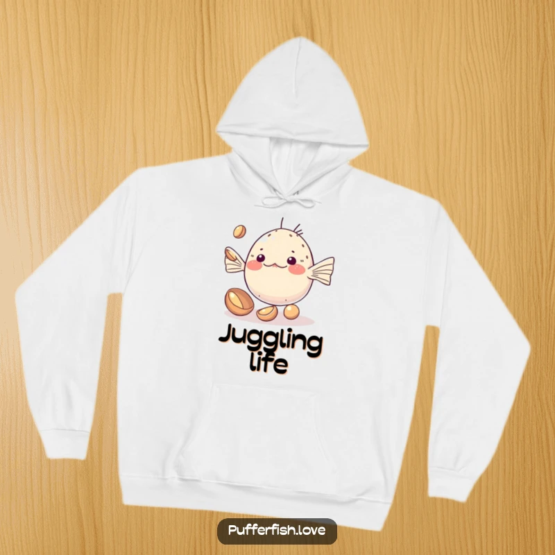 Funny Hoodie of a kawaii pufferfish adorably attempting to juggle small, shiny shells, offering warm comfort and cute charm.